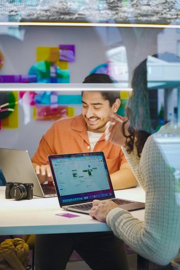 Two people woorking on laptops in co-working space
