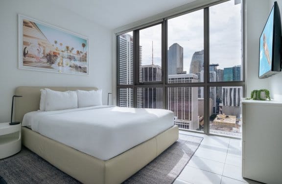 Bright and airy hotel room bedroom area with a huge kitchen area with views of Miami Downtown