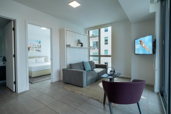 Large hotel studio room with a living area, floor to ceiling windows and a separate bedroom