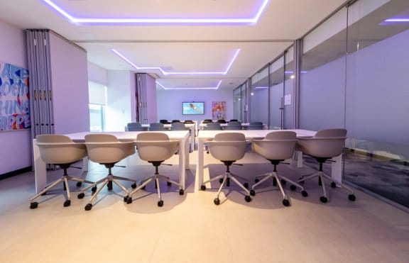 Futuristic classroom-style meeting room with 18 seats facing a large flatscreen TV