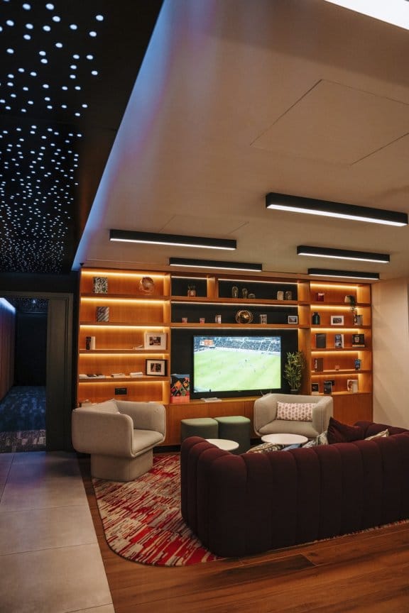 A movie plays on a large flatscreen TV in a warm lounge setting