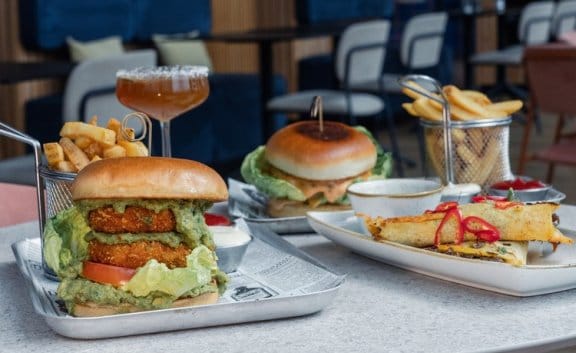 A restaurant table showing burgers and sides