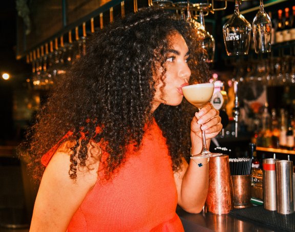 Woman drinking cocktail at a bar
