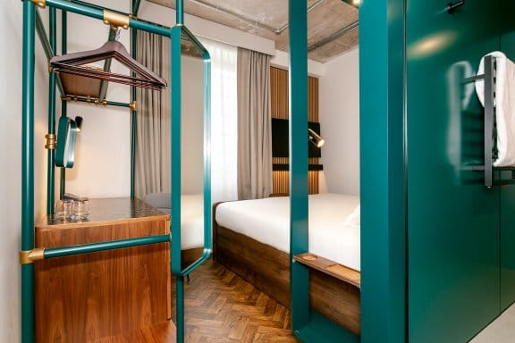 View of bedroom showing desk, bed and window