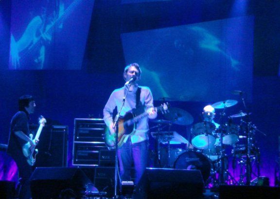 A singer, guitarist, bassist and drummer perform on stage. It's Radiohead!