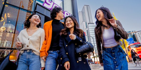 Group of friends laughing in front of Yotel Toyko building