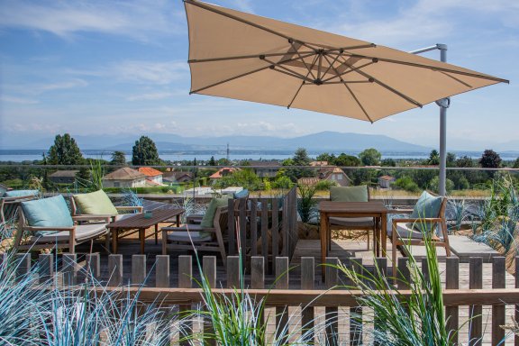 An outdoor terrace with lush greenery and alpine views