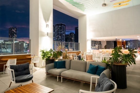 An ourdoor rooftop bar at night with downtown Miami's skyline in the background