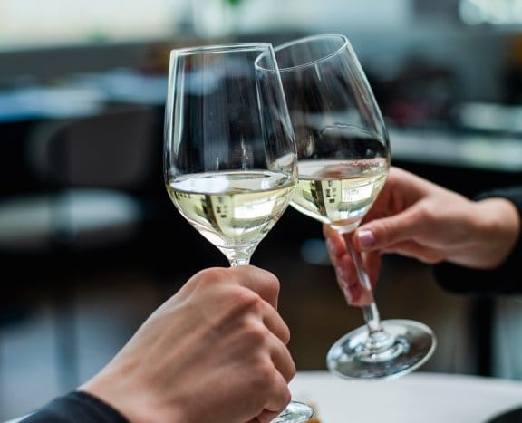 Two wine glasses clinking