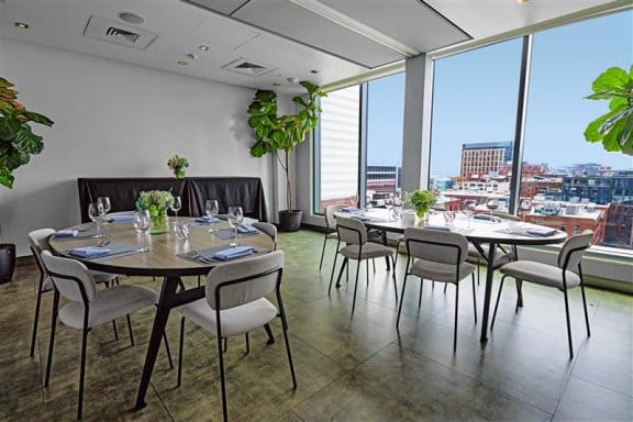 Large room with tables and chairs with large windows