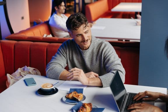 Man and woman seated talking with breakfast food and drinks