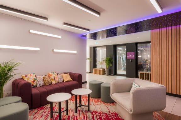 Seating area with purple and white sofas and red carpet