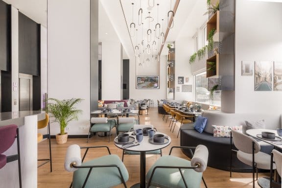 Restaurant showing high ceilings, pale blue chairs and wooden floors