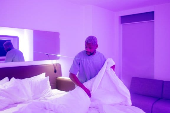 A man relaxes in a clean, modern hotel room