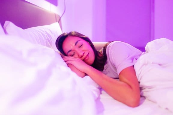 A woman sleeps in a hotel bed