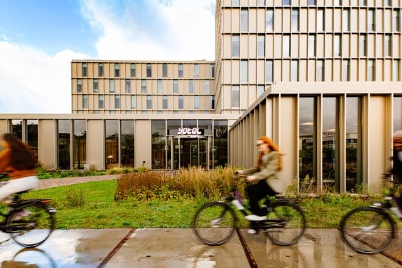 Friends cycle by the outside of YOTEL Amsterdam
