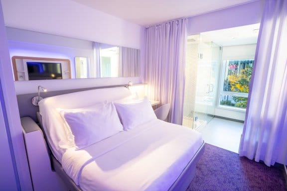 A modern room with large windows and a smartbed