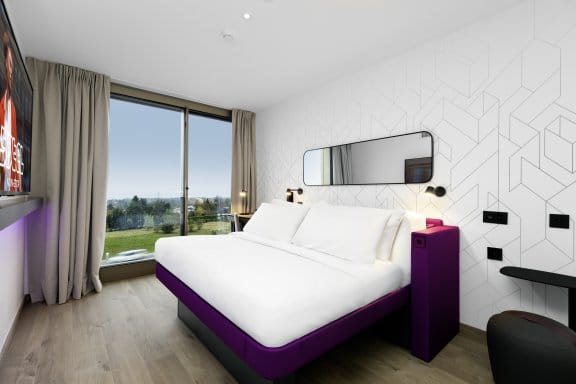 A bright hotel room with views of the alps