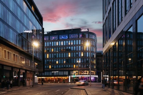 Exterior view of a modern glass building at dusk 