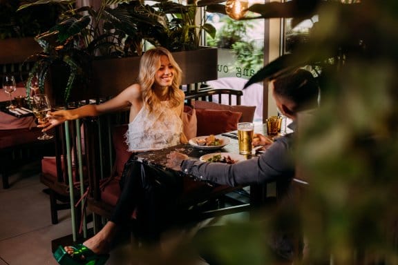 A couple enjoy food & wine in a vibrant hotel restaurant