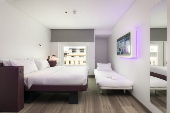 Hotel guest room depicting a queen bed and rollaway single bed