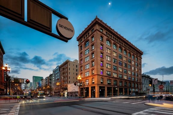 An elegant hotel on the corner of Seventh street, at dusk