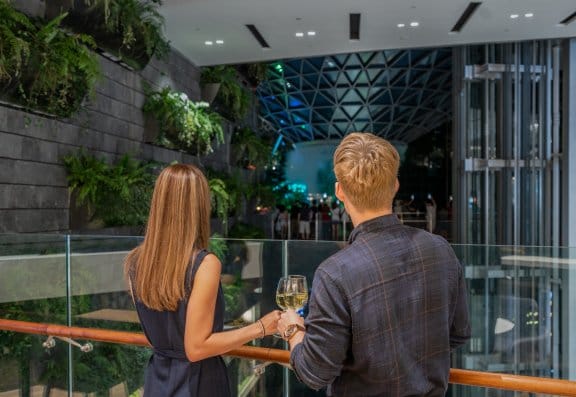 A couple toast wine as they admire the view