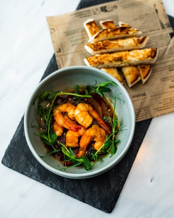 Bowl of prawn salad and bread on the side