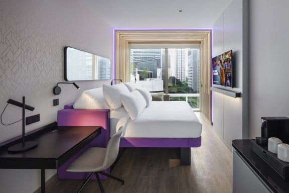 Hotel room with double bed, desk and city view 