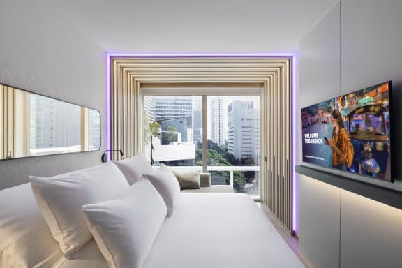 Bedroom with bed in foreground and city view