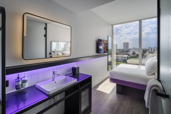 Hotel bedroom with basin, mirror and bed