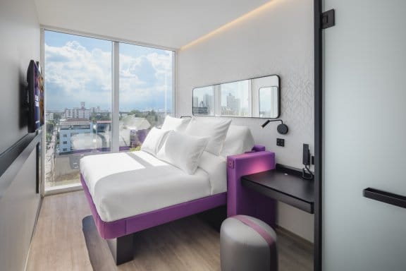 Hotel room with double bed, desk and city view 