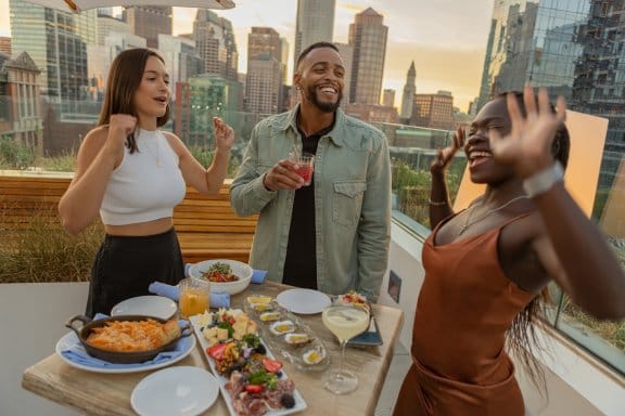 Three friends dance at an outdoor bar