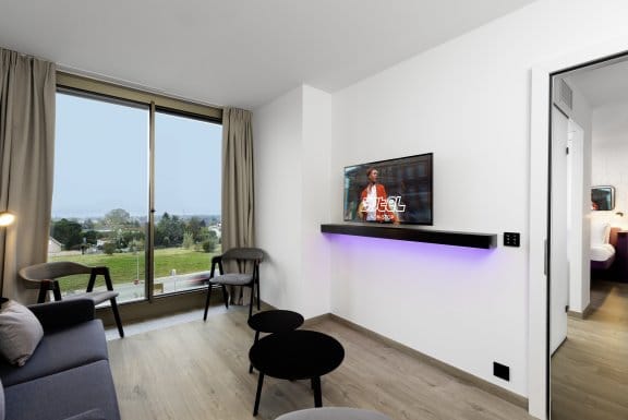 A large hotel room with floor-to-ceiling windows