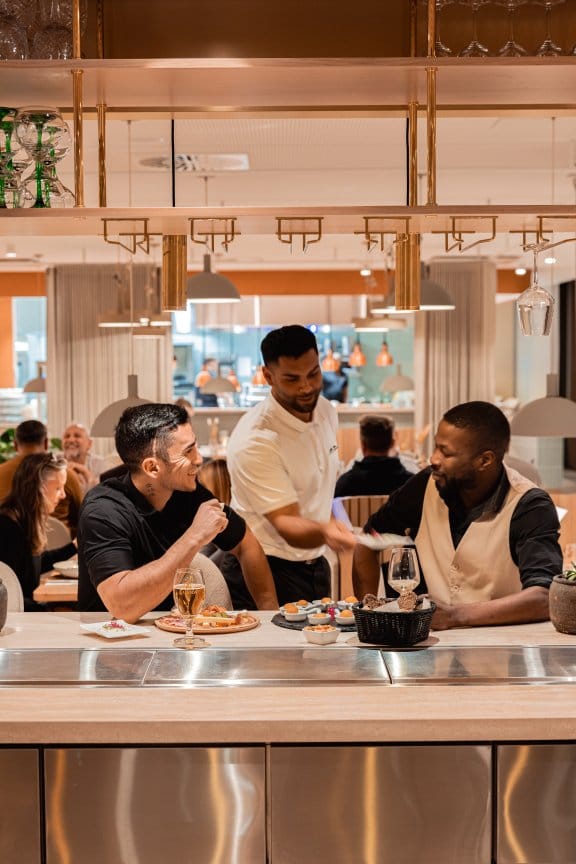 Three friends share a drink in a clean, modern restaurant 