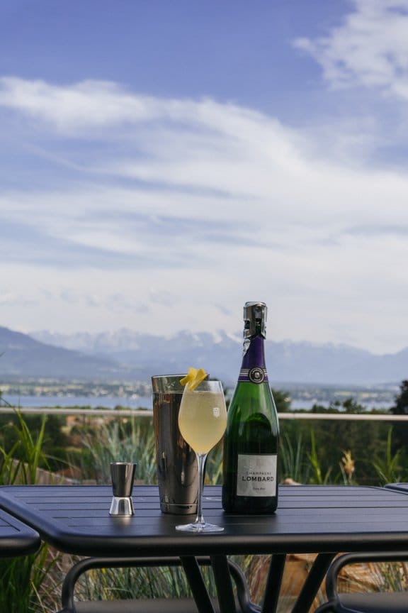 A glass of wine on a table overlooking the Swiss alps