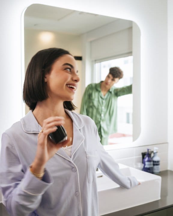 A couple laugh in a hotel bathroom
