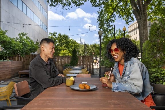 A couple enjoy food and drink outside