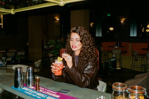 A woman at the bar admiring her cocktail