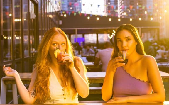 Two girls enjoy a drink on an out door terrace in New York