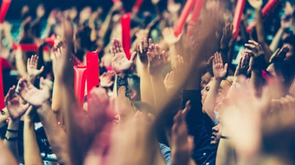 Football fans cheer on a game in a large stadium