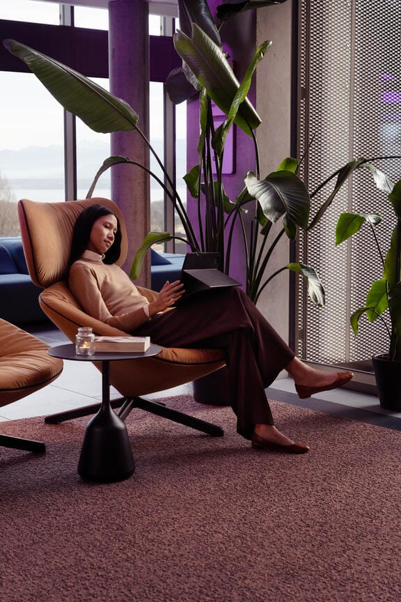 A girl sits on a reclining chair in hotel reception