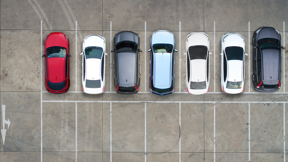Seven cars parked in a line in a carpark