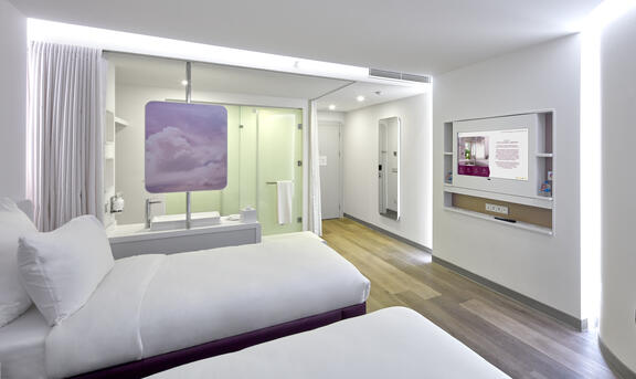 YOTEL Istanbul Airside Premium queen room shows spacious room with two twin rooms, large bathroom and TV