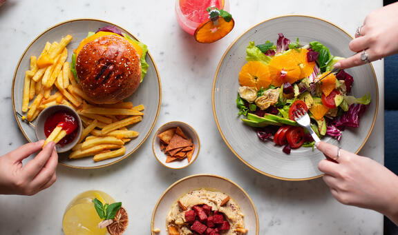 Overhead shot of dinner at YOTEL Istanbul Landside restaurant with salad and burger