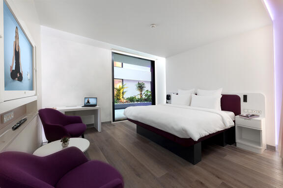YOTEL Istanbul Airside large room shows SmartBed with two purple chairs opposite