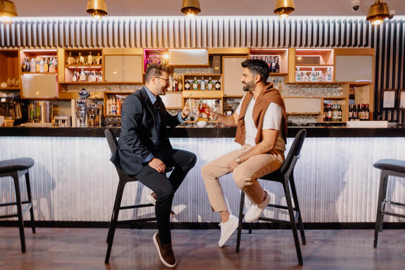 Gentleman couple enjoy drinks at the Komyuniti Bar at YOTEL Istanbul Landside