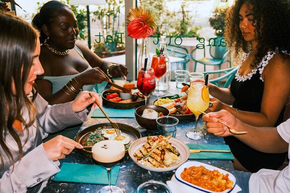 A group of friends eat and drink in a hotel restaurant