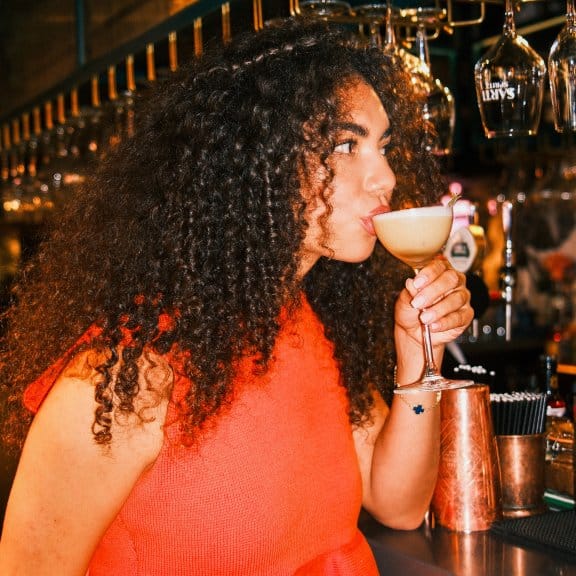 Woman drinking cocktail at a bar