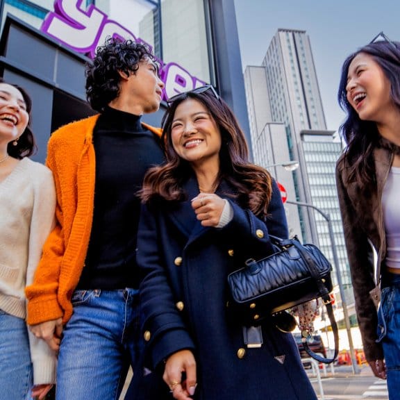 Group of friends laughing in front of Yotel Toyko building